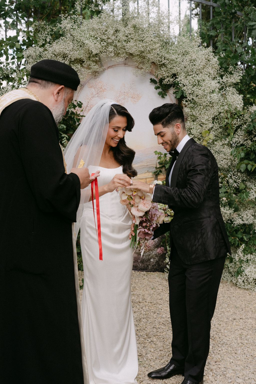 Image may contain Mena Massoud Clothing Formal Wear Suit Adult Person Wedding Hat Footwear Shoe and Dress