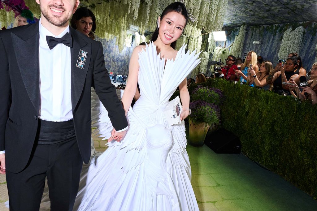 Image may contain Clothing Dress Fashion Formal Wear Gown Wedding Wedding Gown Plant Potted Plant Adult and Person