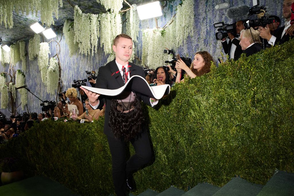 Image may contain Freddie Williams II Andreas Hestler Clothing Formal Wear Suit Person Photobombing Adult and Face
